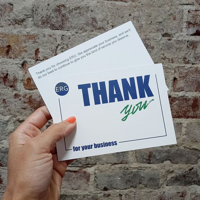 Hand holding a thank you card with large text.