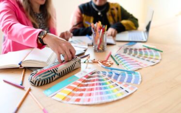 Jolinda and Cierra from Shapes & Colors Team discussing brand color options at a table