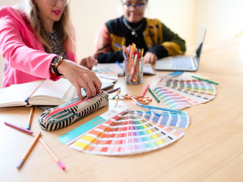 Jolinda and Cierra from Shapes & Colors Team discussing brand color options at a table